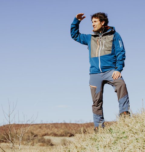 Ö3 Mikromann Tom Walek vor einer kargen Landschaft in Sportbekleidung.