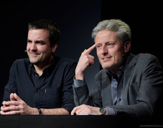 Florian Klenk und Florian Scheuba sitzen nebeneinander vor einem schwarzen Hintergrund.