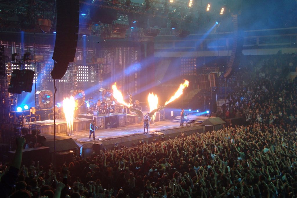 Die Band Rammstein auf der Bühne beim Song „Engel“: Sänger Till Lindemann hat riesige Flügel um, aus denen Feuer schießt.