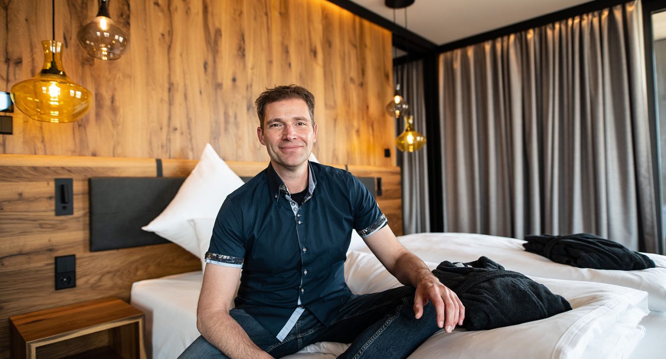 Erich Scheiblhofer entspannt auf einem der Betten im Resort sitzend.