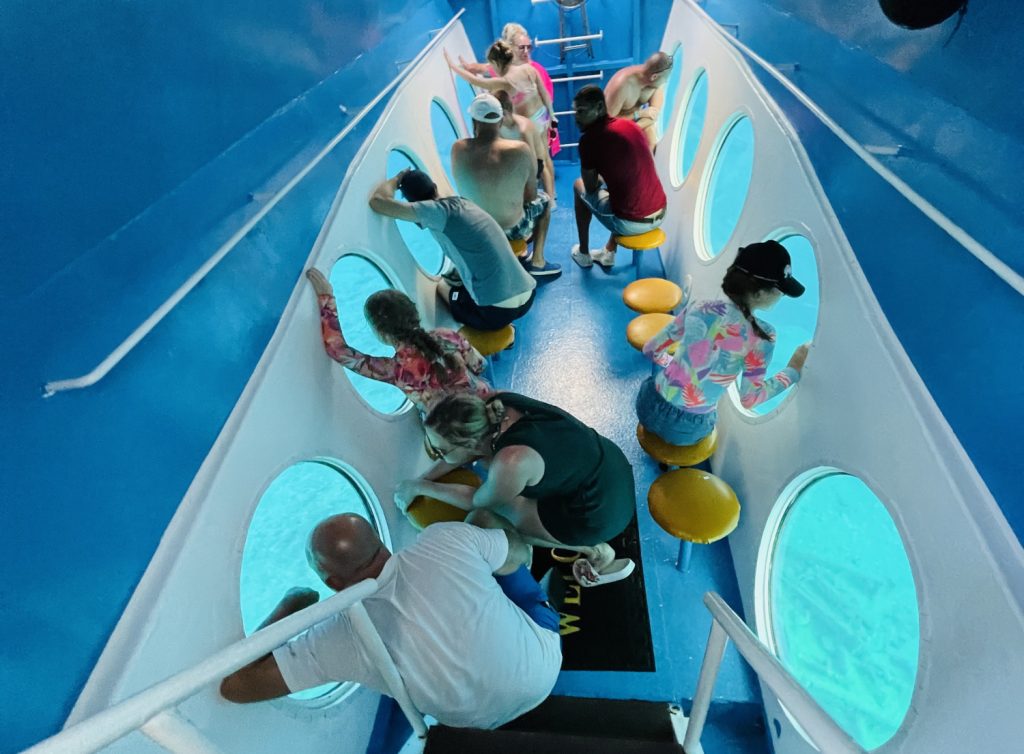 Menschen unter Deck eines Bootes vor runden Luken 