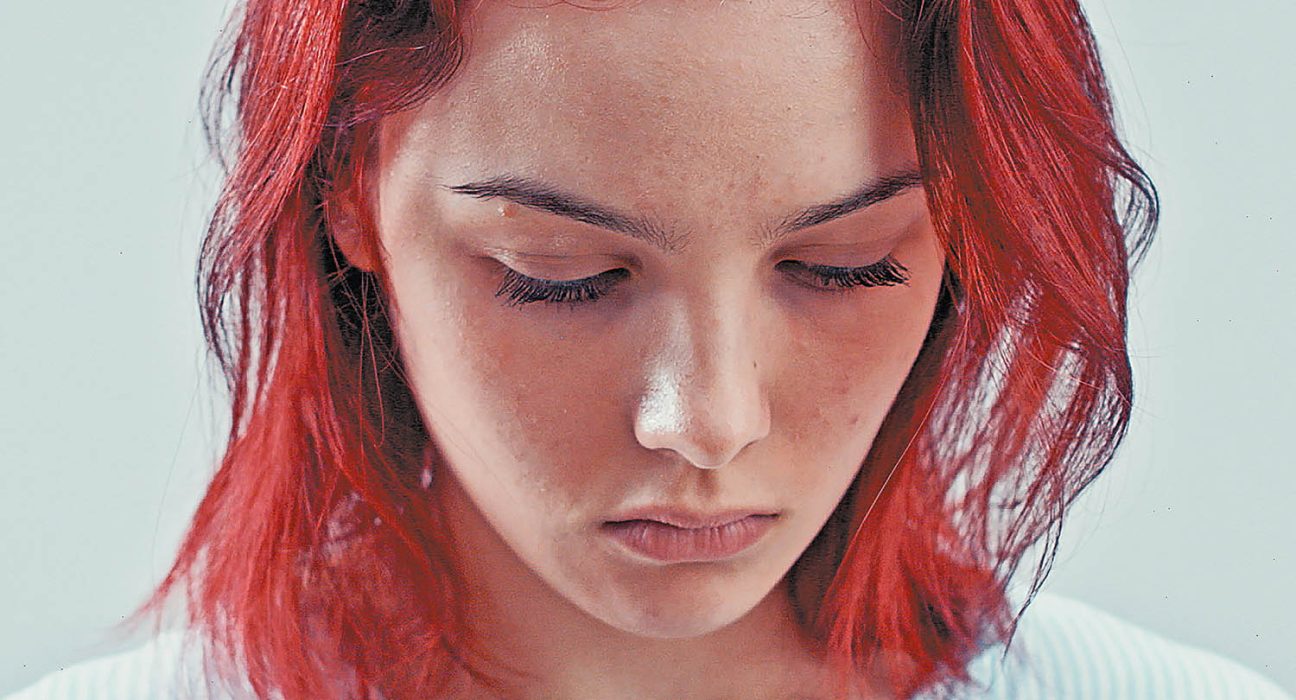 Die Sängerin Laura Del Fiore mit feuerrotem Haar im Porträt. Ihr Blick geht nach unten.