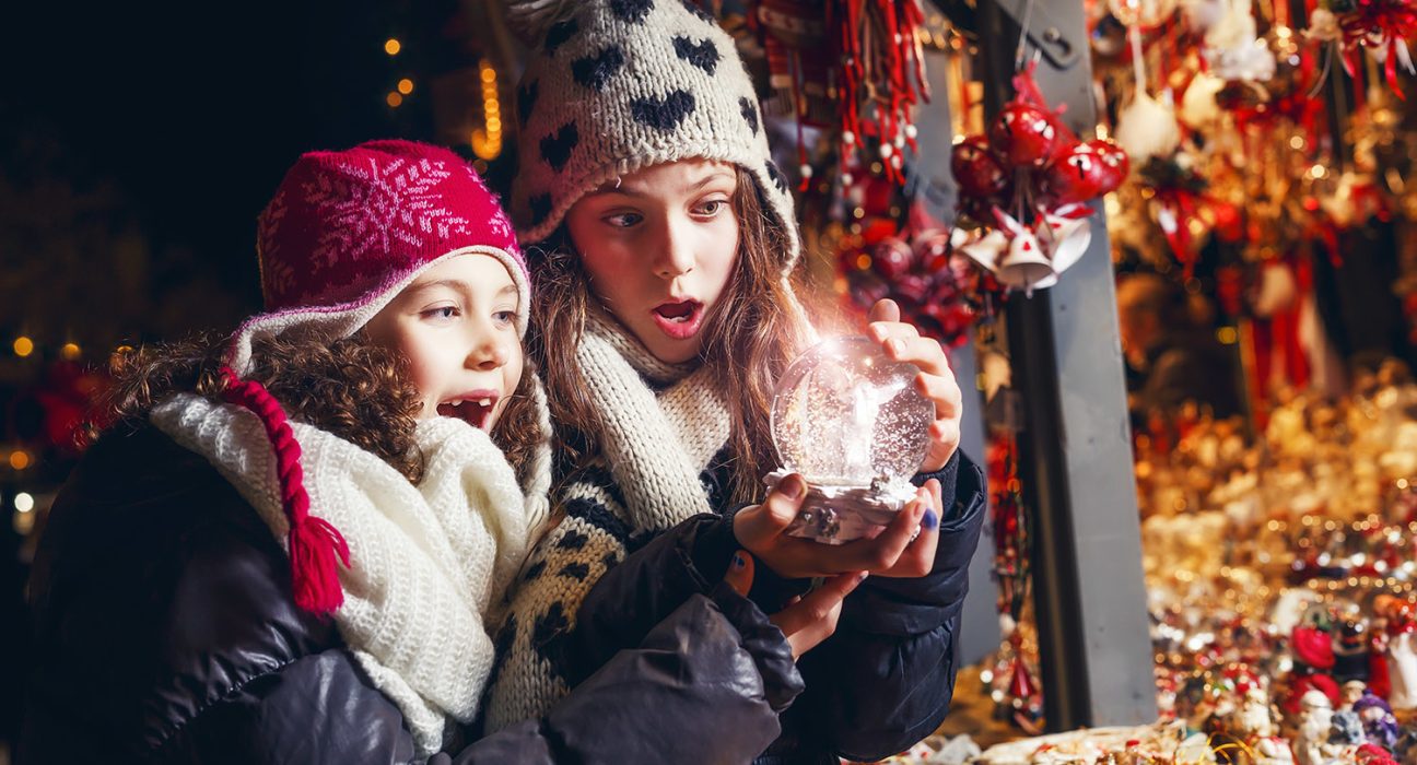 Surprised Girls looking into the crystal ball, pre-christmas period on the christmas market