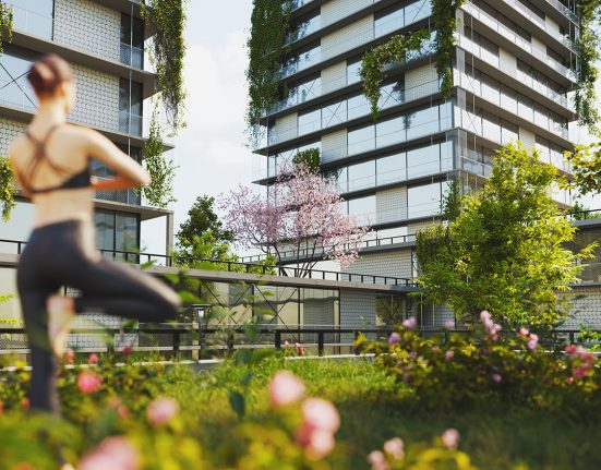 Frau macht Yoga auf einer grünen Terrasse mit Blick auf begrünte Fassaden umliegender Häuser