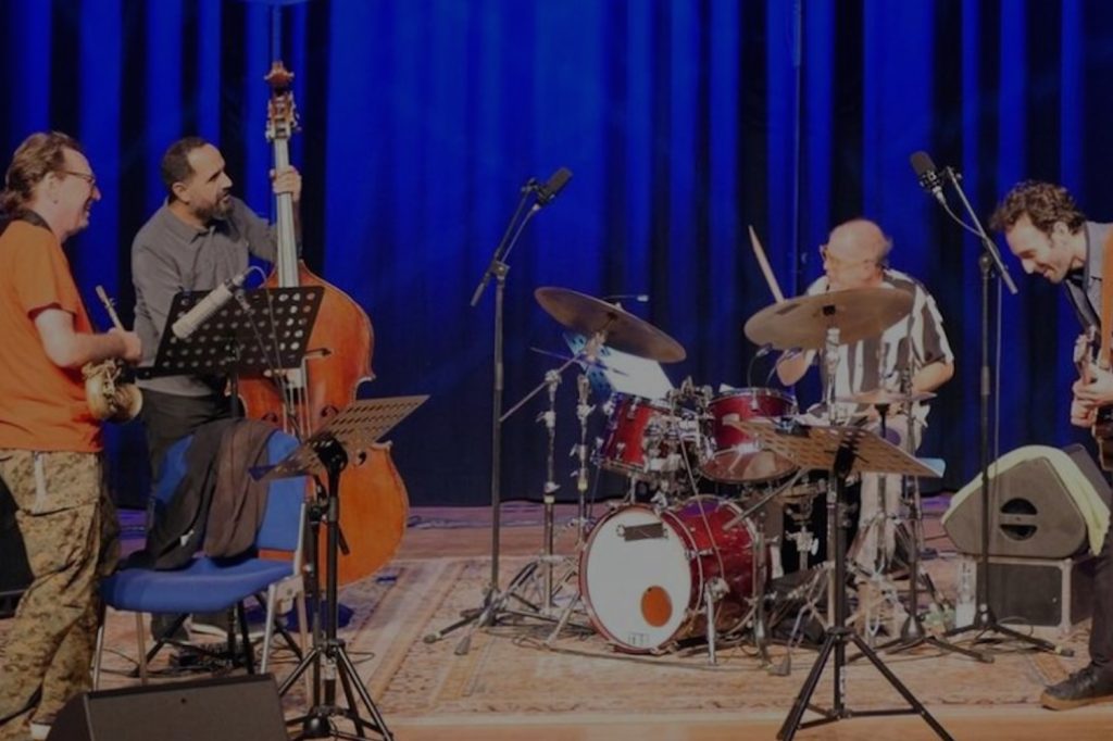 Vier Musiker auf einer Konzertbühne: John Zorn (Saxophon), Bassist Jorge Roeder, Kenny Wollesen (Schlagzeug) und Gitarrist Julian Lage © Ingrid Hoberg