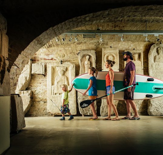 Familie mit Surfboard im Lapidarium 1 des Landesmuseum Burgenland