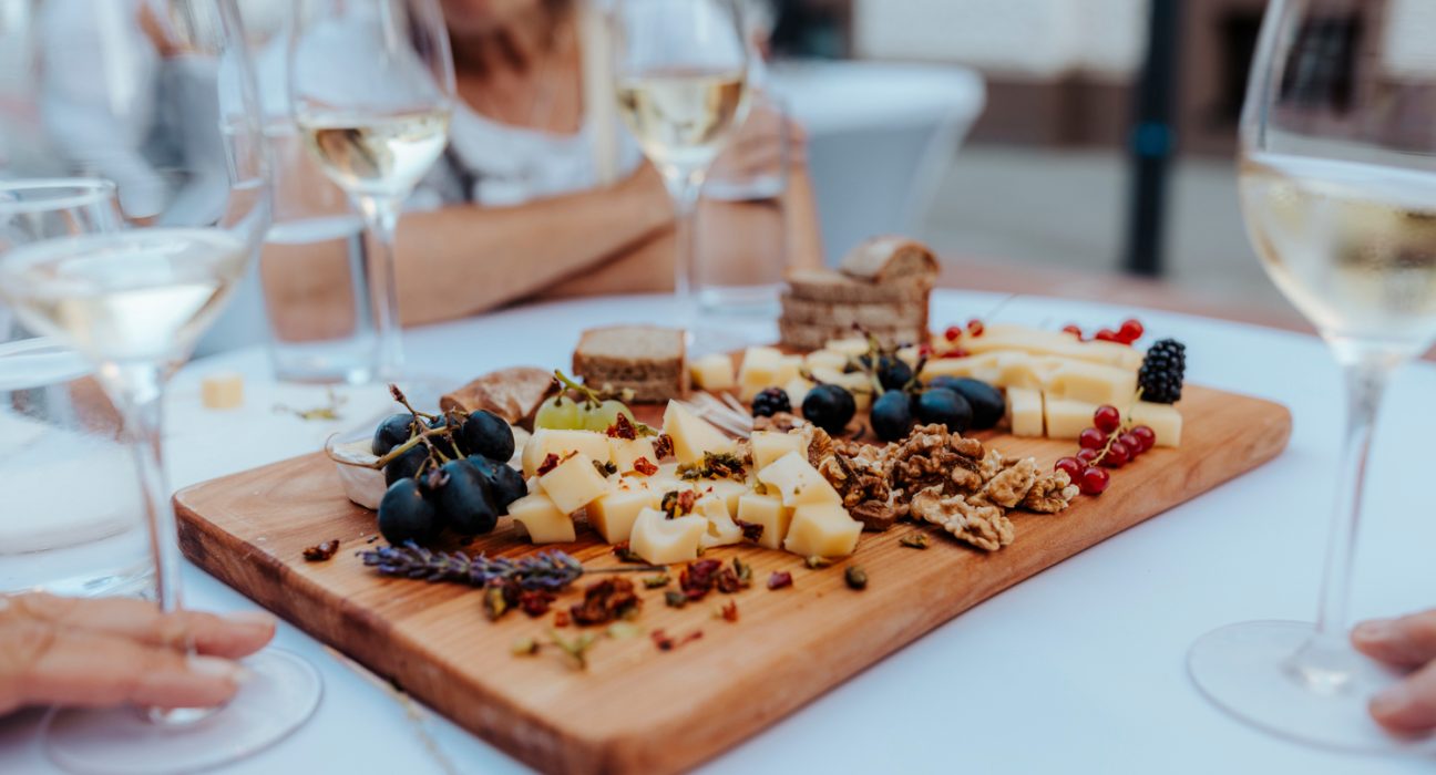 Ein Snackboard auf einem Tisch mit Weingläsern