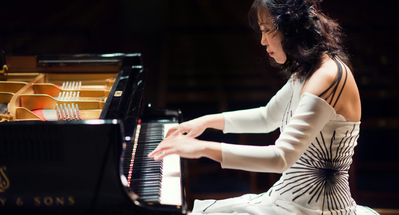 Die Konzertpianistin SoRyang während sie an einem Piano sitzt und spielt.