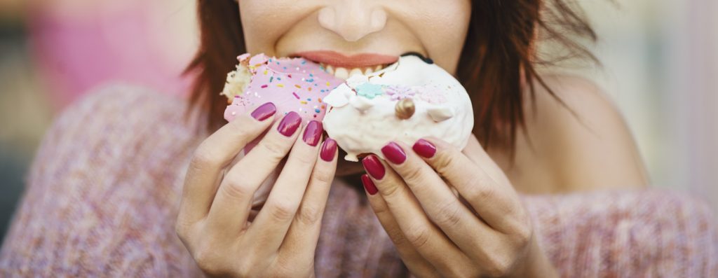 Frau isst Zucker-Donuts