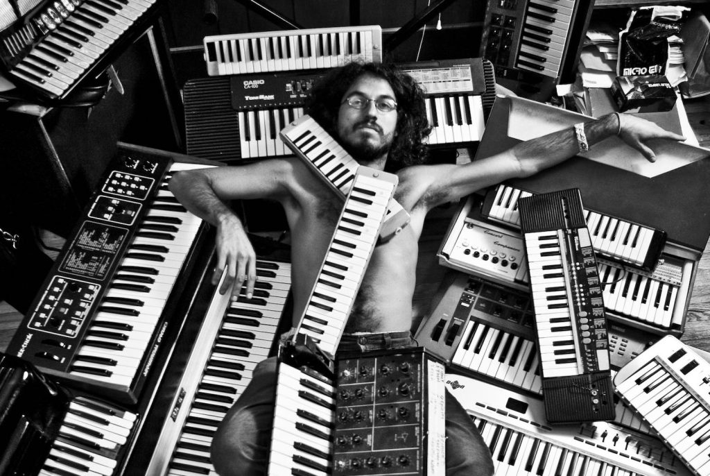 Leo Genovese liegt inmitten von vielen Keyboards am Boden, einige liegen auch auf ihm © Carlos Pericas