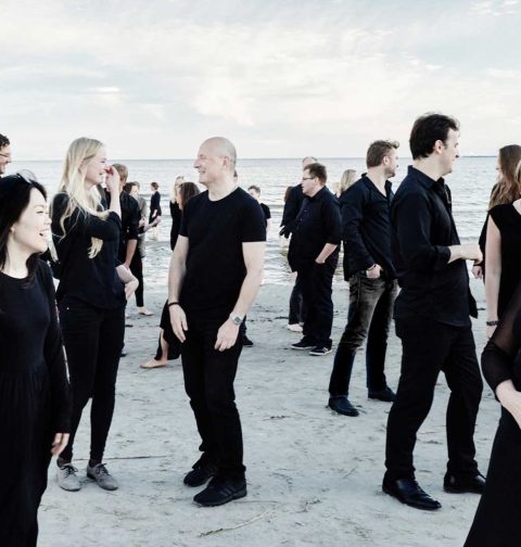 Musiker des Estonian Festival Orchestra in schwarzer Kleidung an einem Sandstrand. © Kaupo Kikkas