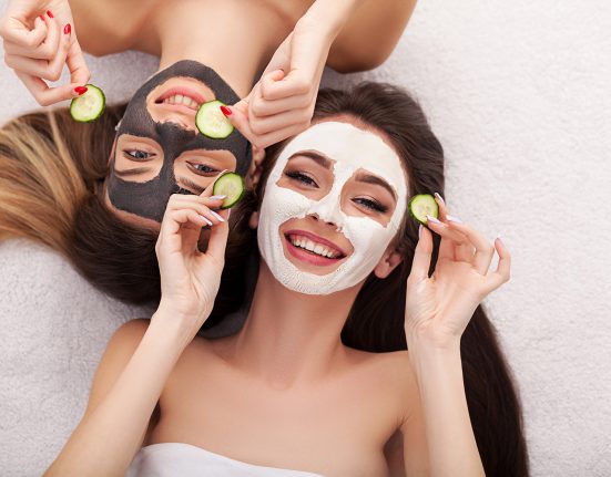 Zwei Frauen mit Gesichtsmasken und Gurken um ihre Haut zu pflegen