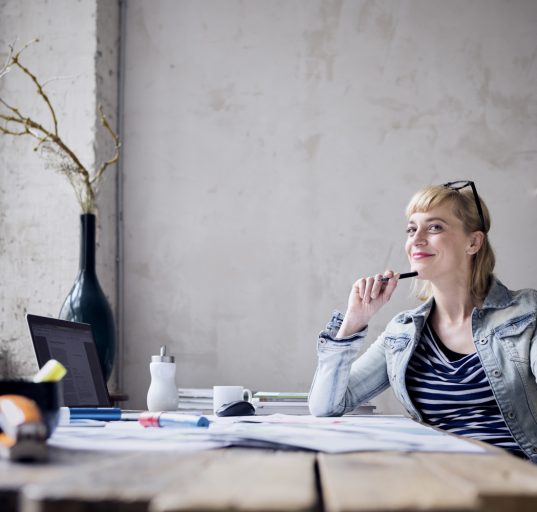 Frau sitzt am Schreibtisch im Büro
