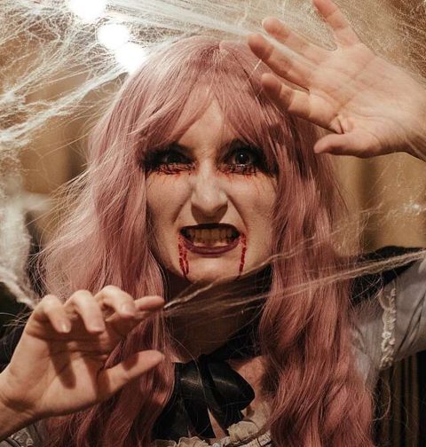 Eine Vampirfrau, der Blut beim Mund herausläuft, umgeben von Spinnweben. (Bild zu Halloween-Special) © Schloss_Schoenbrunn_Kultur-_und_BetriebsgesmbH_Michal_Cilc