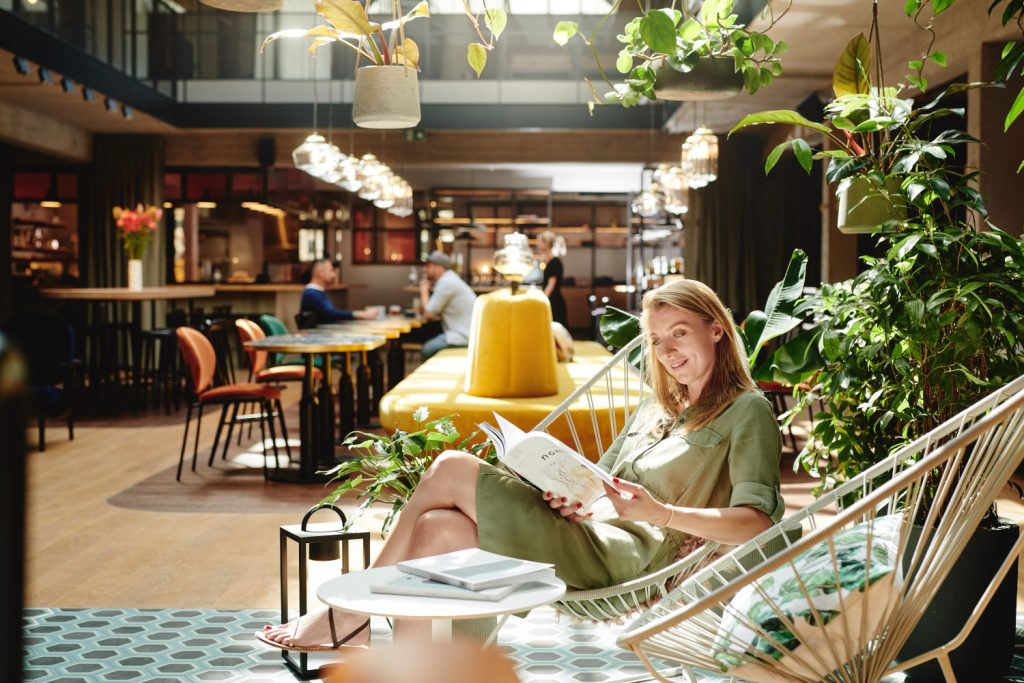 Frau sitzt im grünen Bereich des Hotel Gilbert in Wien