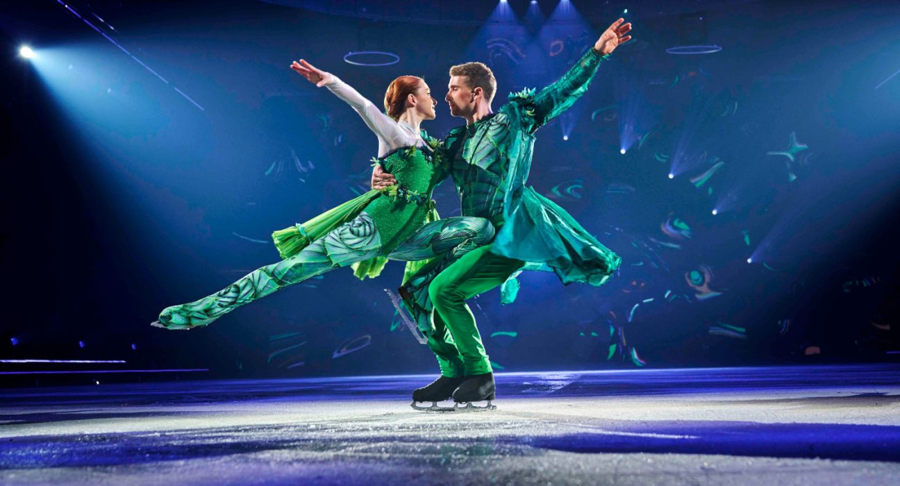 zwei Eiskunstläufer in grünen Kostümen bei einer Figur