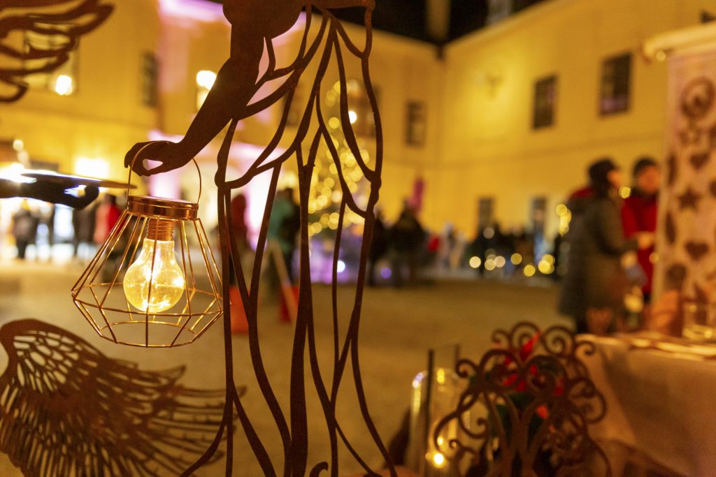 Deko-Leuchte vor dem Schloss Eckartsau. Leuchte im Fokus, im Hintergrund Menschen vor Marktständen