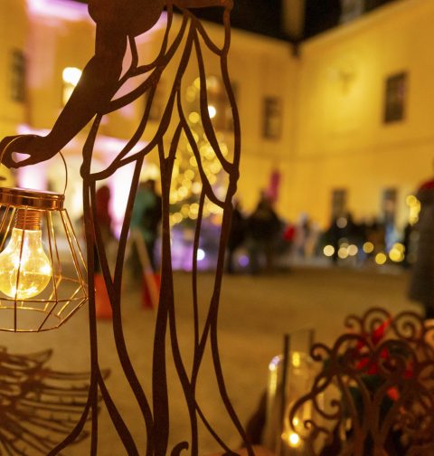 Deko-Leuchte vor dem Schloss Eckartsau. Leuchte im Fokus, im Hintergrund Menschen vor Marktständen