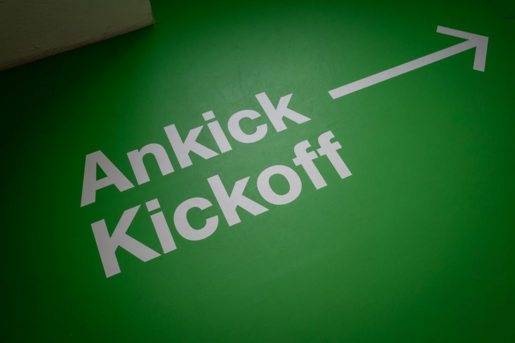Beschriftung am Boden: Ankick/ Kickoff, Schrift ist weiß, Boden ist grün