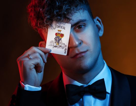 Portraitfoto des Magiers Fab Fox mit einer Spielkarte vor dem rechten Auge