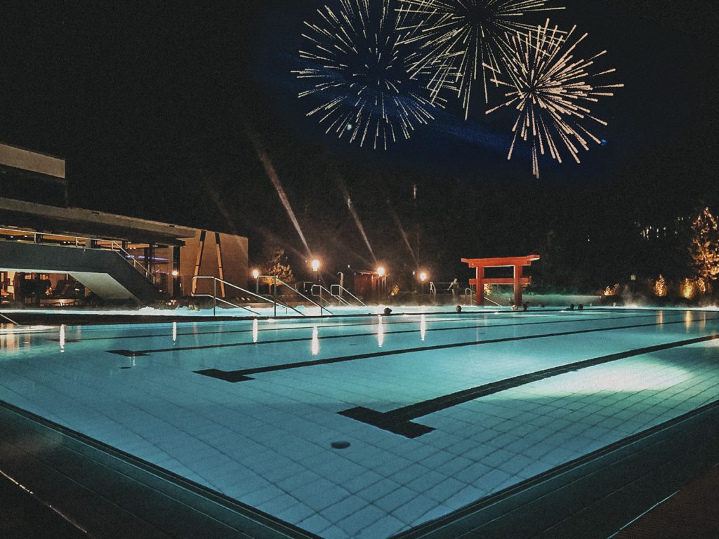 Feuerwerk in Linsberg. Beleuchteter Pool in der Therme, Feuerwerk am Nachthimmel