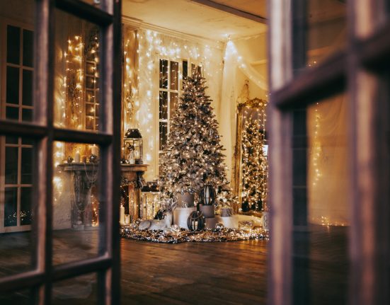 Sicht auf ein weihnachtlich geschmücktes Zimmer mit Weihnachtsbaum und Lichterketten