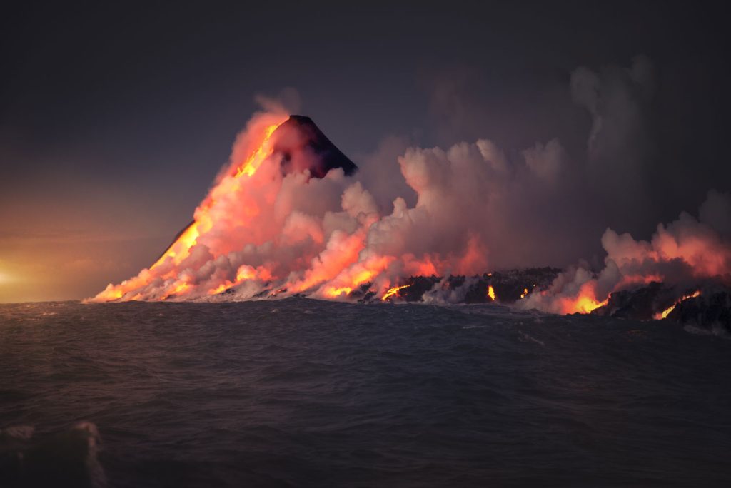 Blick vom Wasser Richtung Big Island in Hawaii und KI-generierten lavaspeienden Vulkan