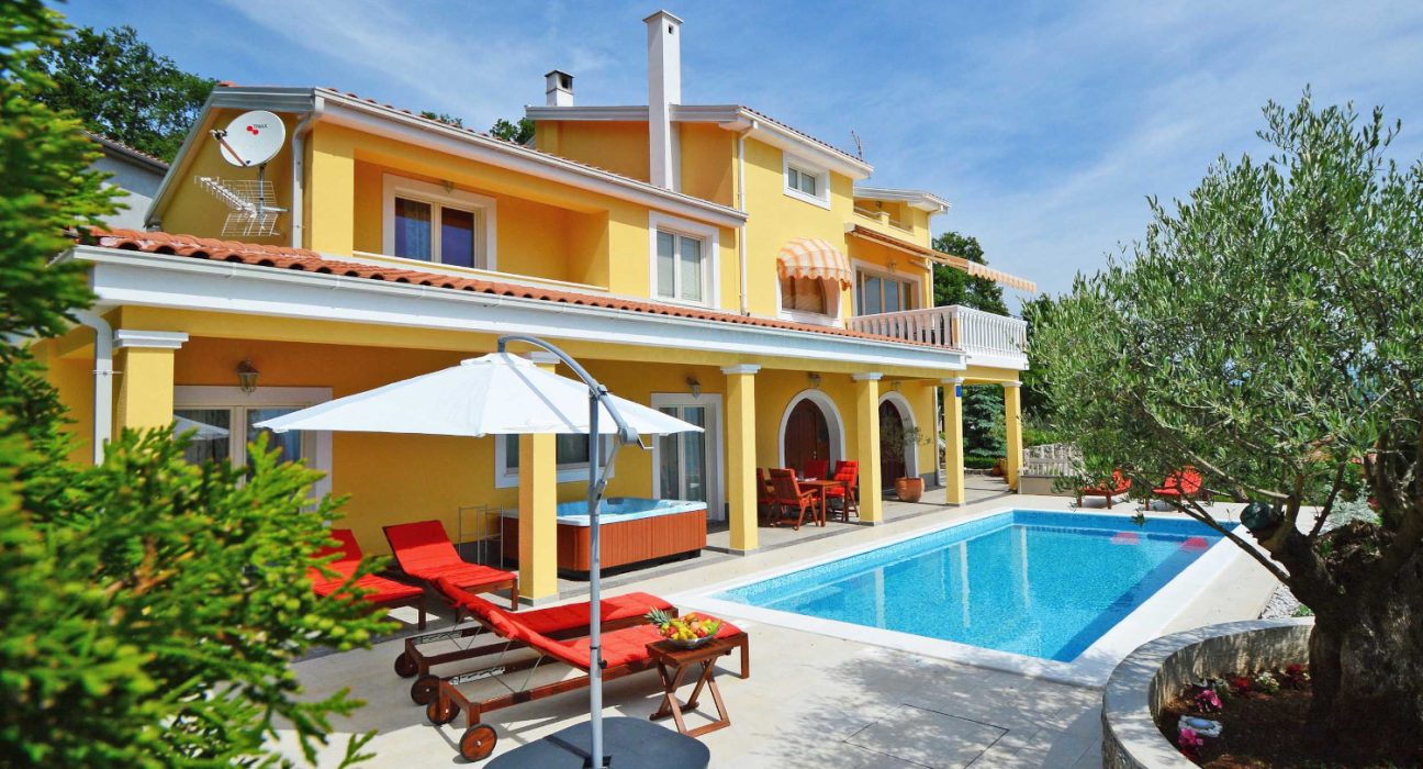 Gelbes Ferienhaus von INTERHOME mit Pool, Liegebetten und mediterranen Pflanzen