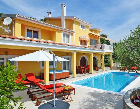 Gelbes Ferienhaus von INTERHOME mit Pool, Liegebetten und mediterranen Pflanzen