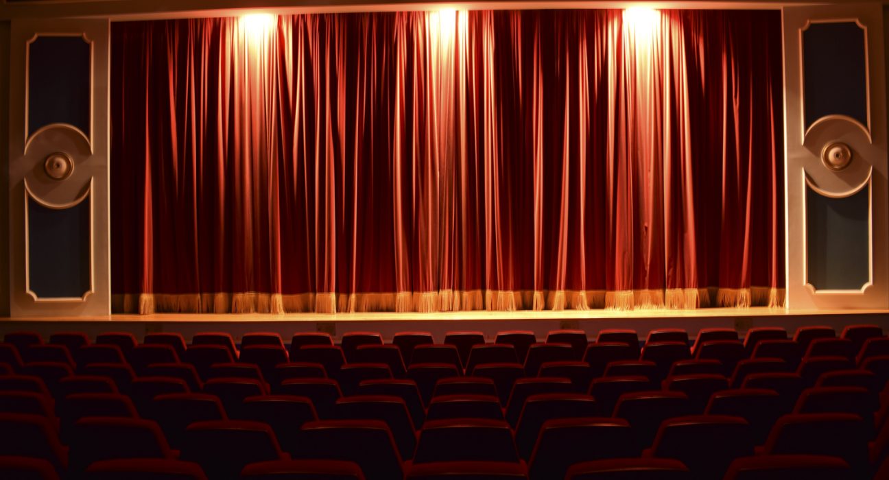 Gloria Theater: Leerer Saal mit roten Stühlen und rotem beleuchteten Vorhang