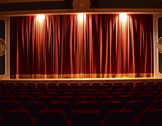 Gloria Theater: Leerer Saal mit roten Stühlen und rotem beleuchteten Vorhang
