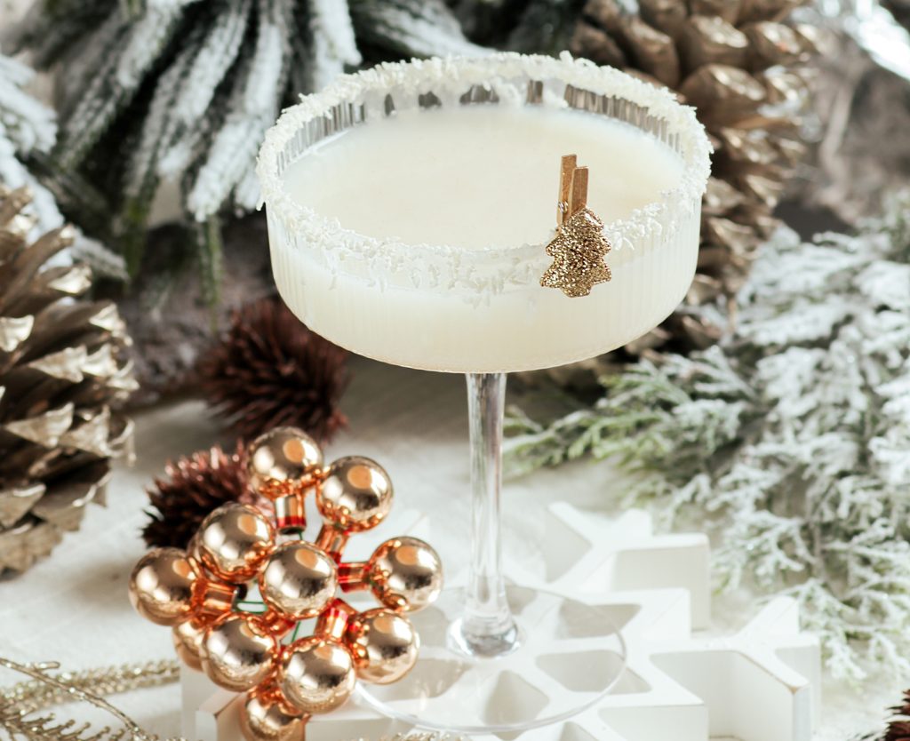 Coconut Christmas Mojito mit goldener Deko und Kokosflocken-Rand für weihnachtliche Cocktails.