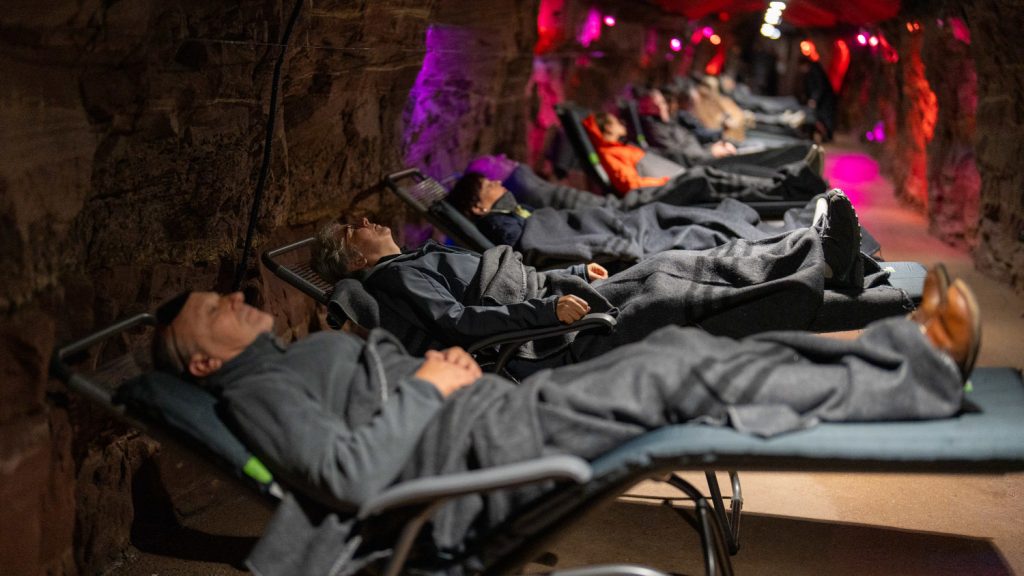 Menschen auf Entspannungsliegen bei gedimmtem Licht im Heilstollen in Neubulach
