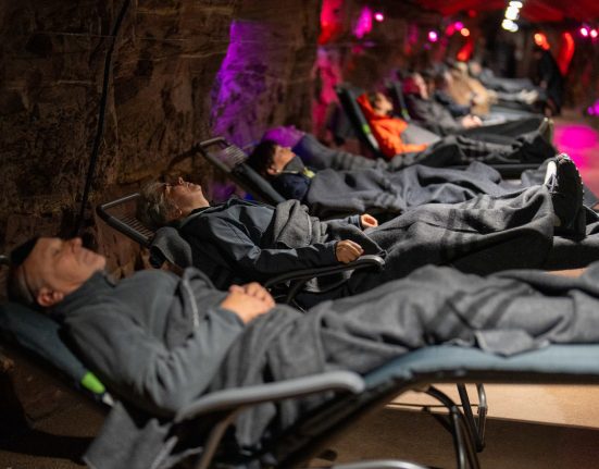Menschen auf Entspannungsliegen bei gedimmtem Licht im Heilstollen in Neubulach