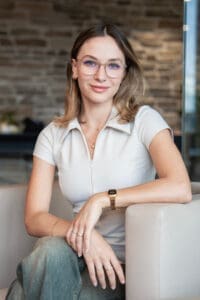 Frau sitzt auf Fauteuil vor Ziegelwand