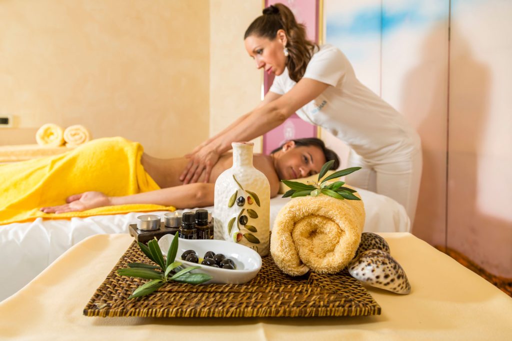 Frau erhält Massage mit Olivenöl