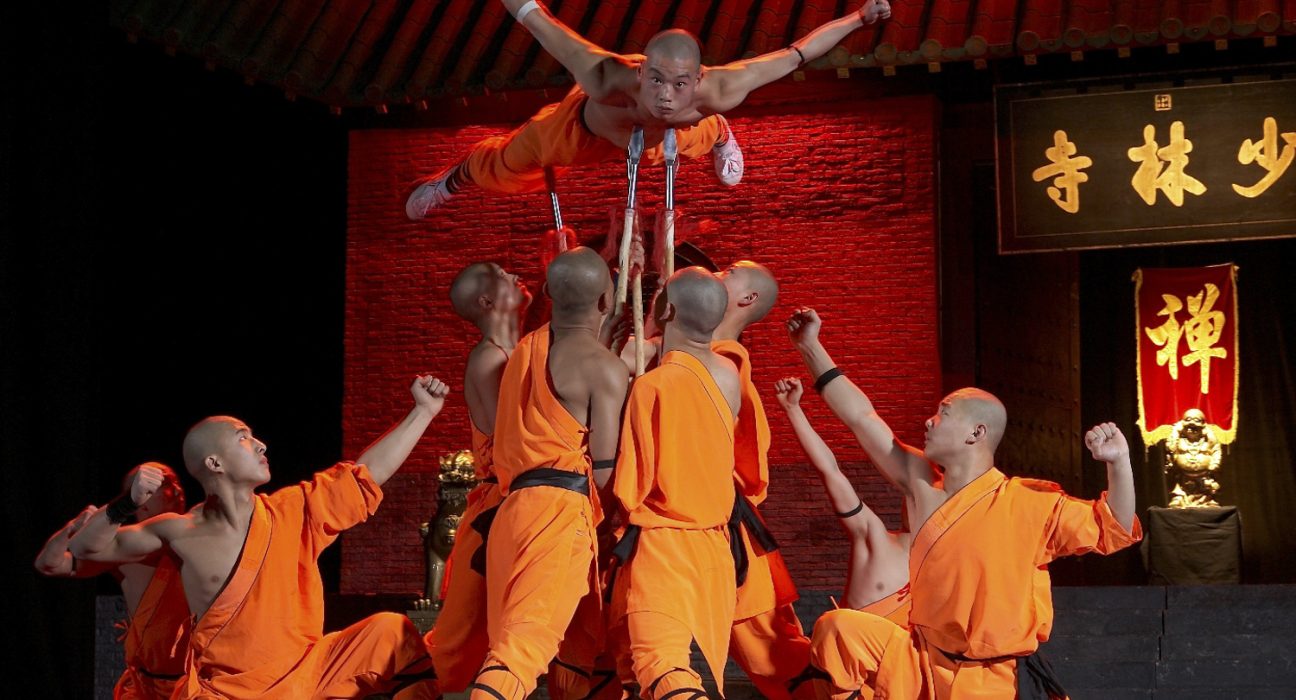 Shaolin Mönche in Action: Mönch balanciert mit seinem Körper auf ein paar wenigen Speerspitzen.
