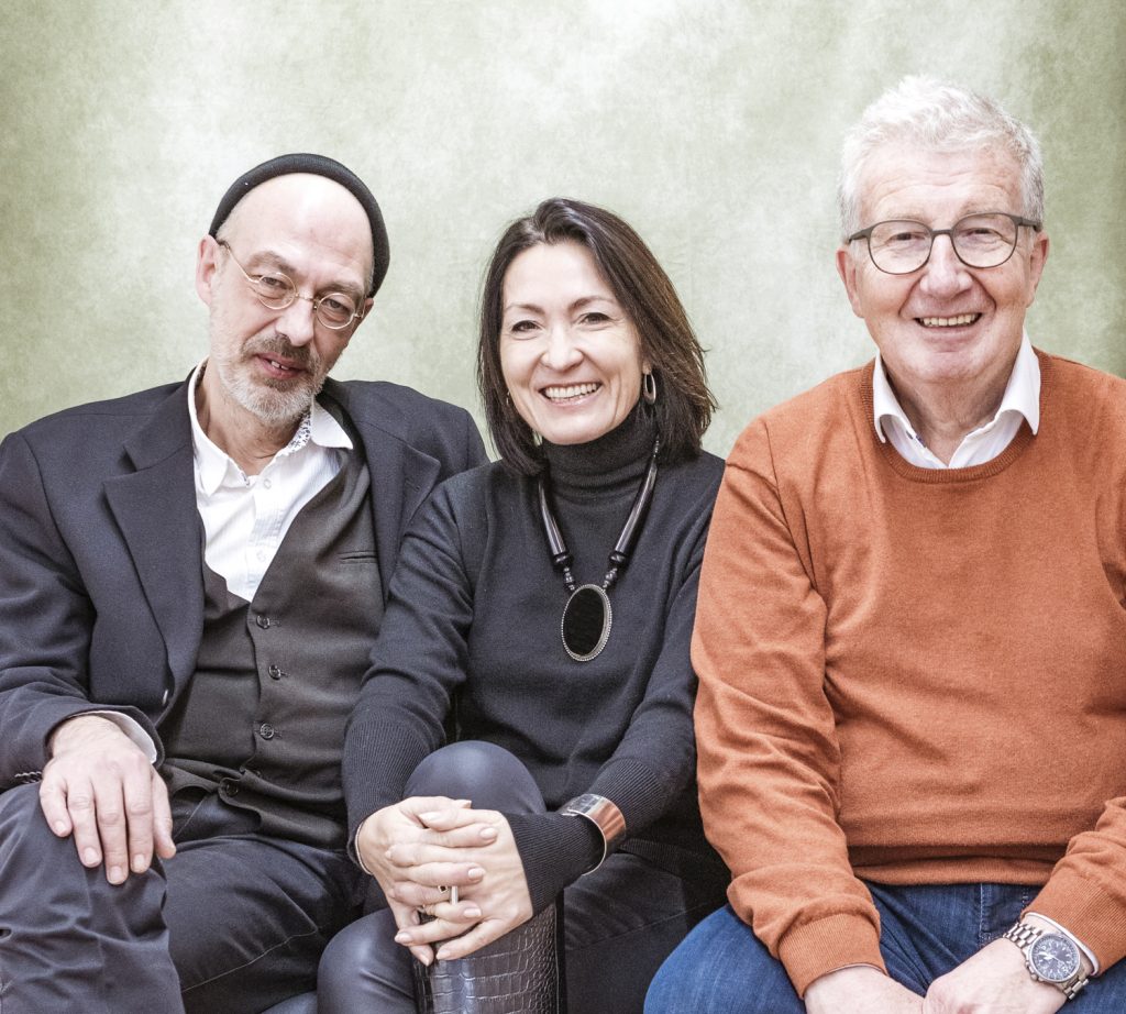 Christian Baier, Sonja Soukup und Erwin Kraus sitzen vor beigem Hintergrund
