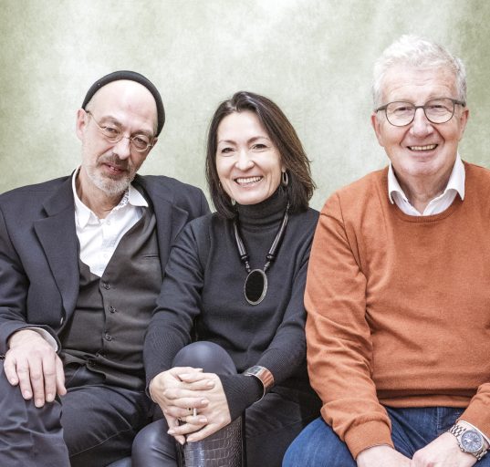 Christian Baier, Sonja Soukup und Erwin Kraus sitzen vor beigem Hintergrund