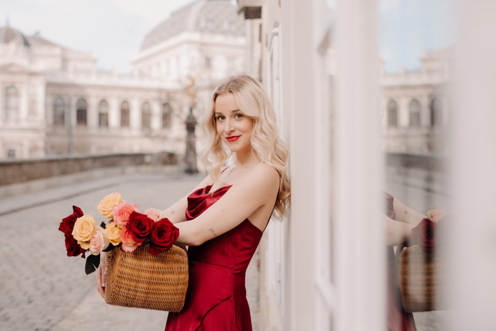 Anna Rosa Döller in einem roten Kleid mit einem Korb Rosen