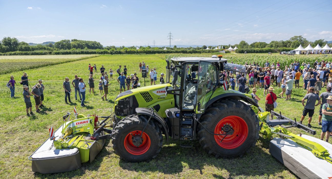 Menschen versammelt um einen Traktor auf einem Feld