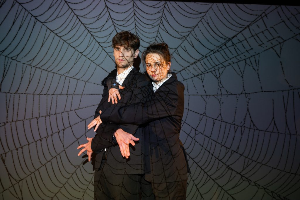 Julian Tzschentke und Caroline Baas vor einem Spinnennetz