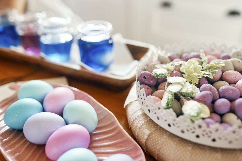Gefärbte Ostereier liegen auf einem Tisch mit Lebensmittelfarben