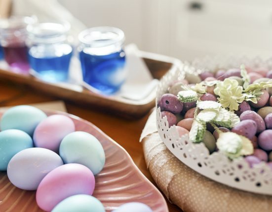Gefärbte Ostereier liegen auf einem Tisch mit Lebensmittelfarben