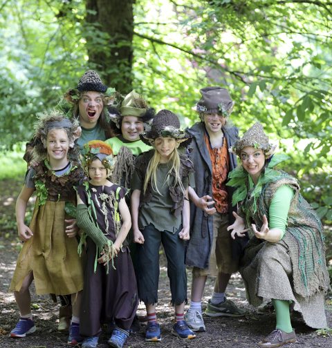 Kostümierte Erwachsene und Kinder im Wald