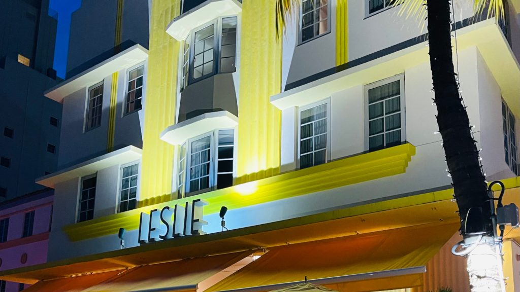 Bei Nacht erleuchtete symmetrische, gelbe Fassade des Leslie Hotel in Miami Beach