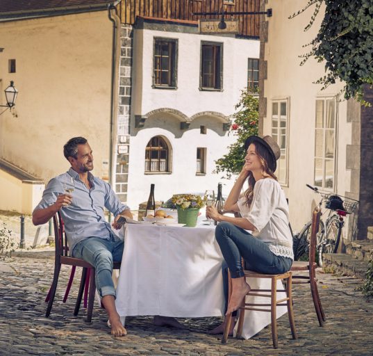Pärchen sitz an einem Tisch in einer Gasse in der Altstadt von Krems