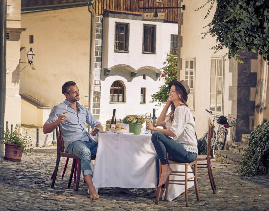 Pärchen sitz an einem Tisch in einer Gasse in der Altstadt von Krems