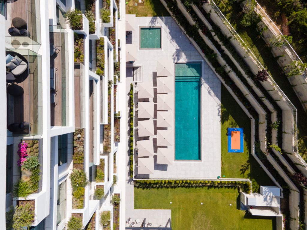 Luftaufnahme des Outdoor-Pools mit Teilen der Fassade des Cityhotels Martinhal Lisbon Oriente