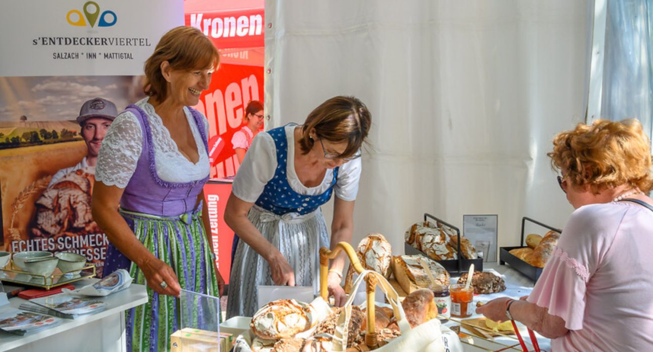 Damen in Tracht verkaufen Brot